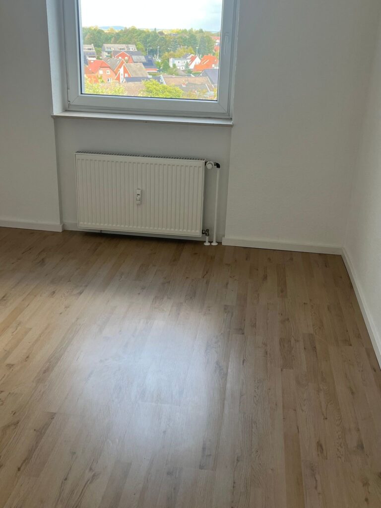 Weiße Wände, Sockelleisten und ein Boden in Holzoptik. Die Aufnahme zeigt die gestalteten Oberflächen.