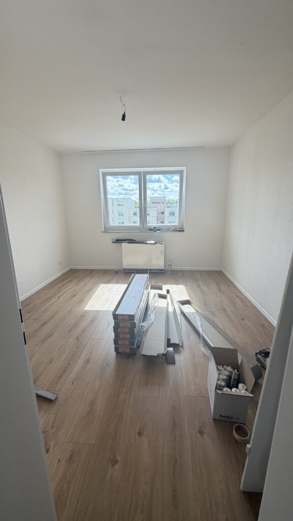 Boden in Holzoptik während der Ausbauarbeiten. Material und Zubehör sind noch im Raum gelagert.